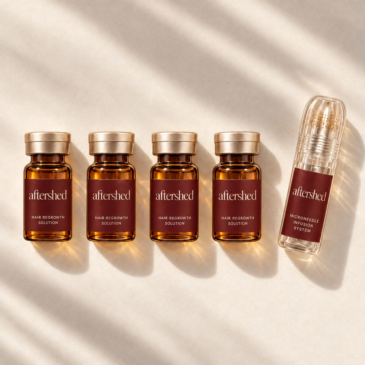 Four AfterShed serum vials and the press stamp on an ivory surface